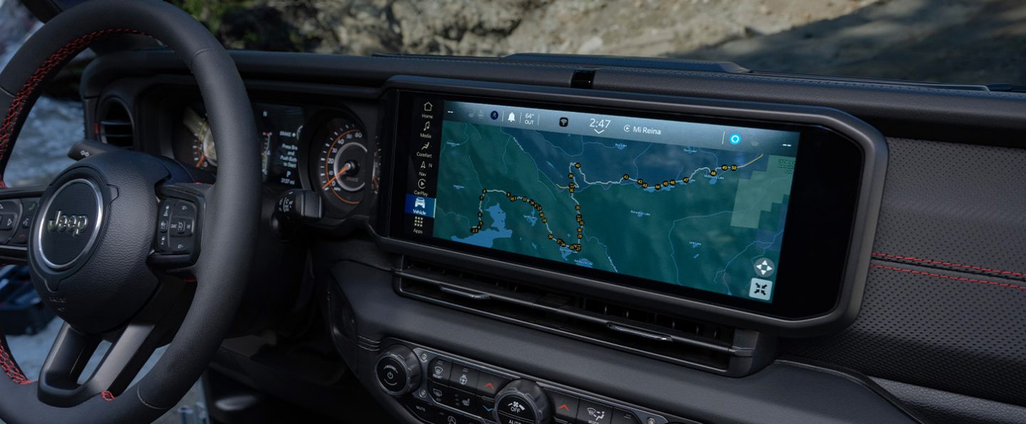 The Uconnect touchscreen in the 2026 Jeep Gladiator displaying one of the Off-Road Adventure Guides with a map of the Rubicon trail.