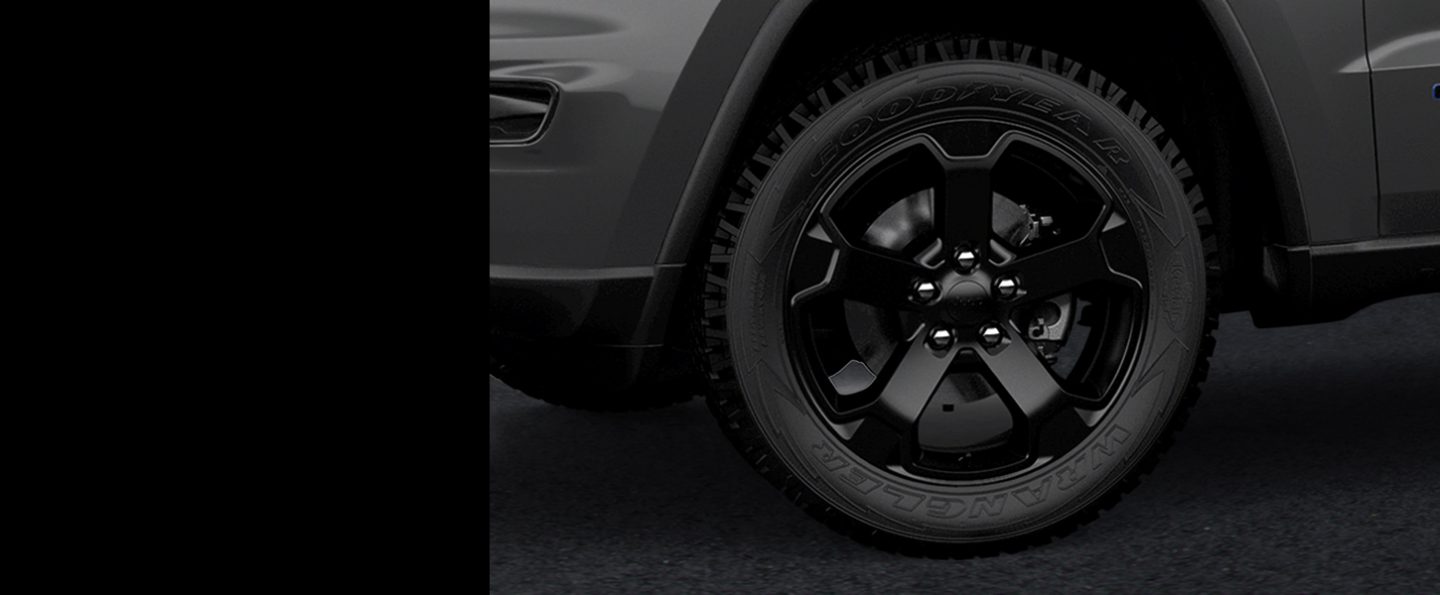 Close-up of one of the gloss black aluminum wheels on the 2020 Jeep Grand Cherokee Upland.