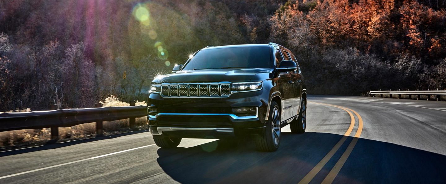 The 2023 Grand Wagoneer Series III being driven on a mountain road in the autumn.